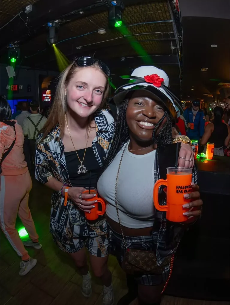 Two friends in Halloween costumes holding drinks at Clarendon Ballroom nightclub in Arlington, VA